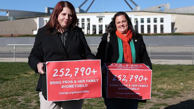 Biloela locals Angela Fredericks and Bronwyn Dendle, whose children played with Kopika and Tharnicaa in Biloela out the front of Parliament House in Canberra with a petition of 250k signatures. Picture Kym Smith