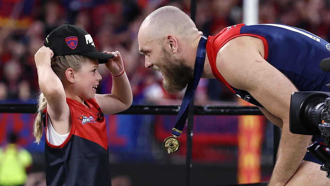 Max Gawn of the Demons gets his medal from a young Auskicker . Photo by Michael Klein