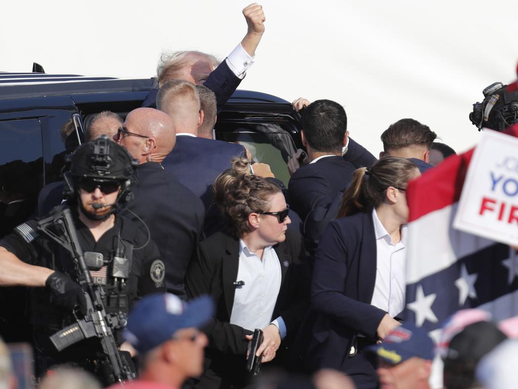 Secret Service agents bundle Trump back to his vehicle. Picture: David Maxwell/EPA/AAP