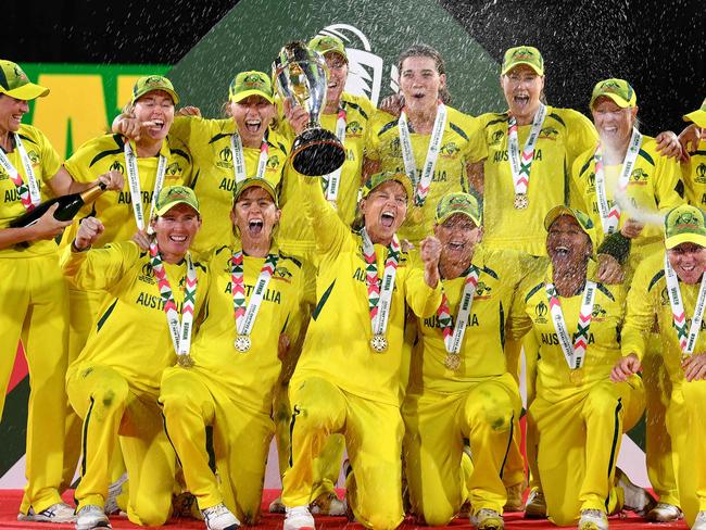 TOPSHOT - Australia's captain Meg Lanning (C) holds the trophy as team celebrate their win after the Women's Cricket World Cup final match between England and Australia at Hagley Park Oval in Christchurch on April 3, 2022. (Photo by Sanka VIDANAGAMA / AFP)