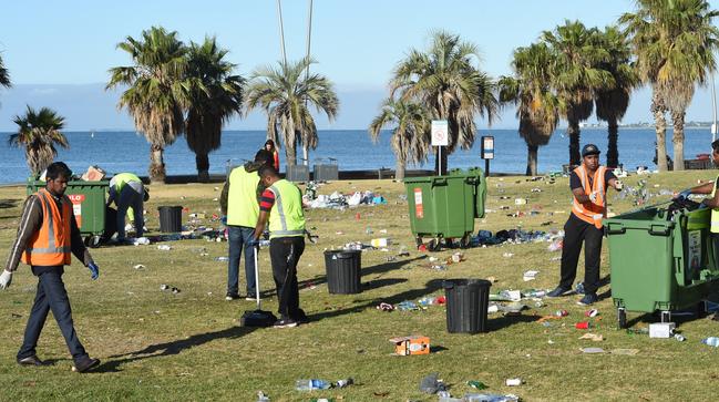 Workers clean up rubbish left on the St Kilda foreshore. Picture: Nicole Garmston