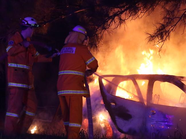 A small hatchback possibly a Hyundi has crashed into a tree with 3 youths on board at 5.20 am on Wilga St Elanora Heights. The males escaped before the car burst into flames setting the bush alight , RFS volunteers along with police and Ambulance attended treating the males and arresting the driver for failing a breath test. Pic John Grainger