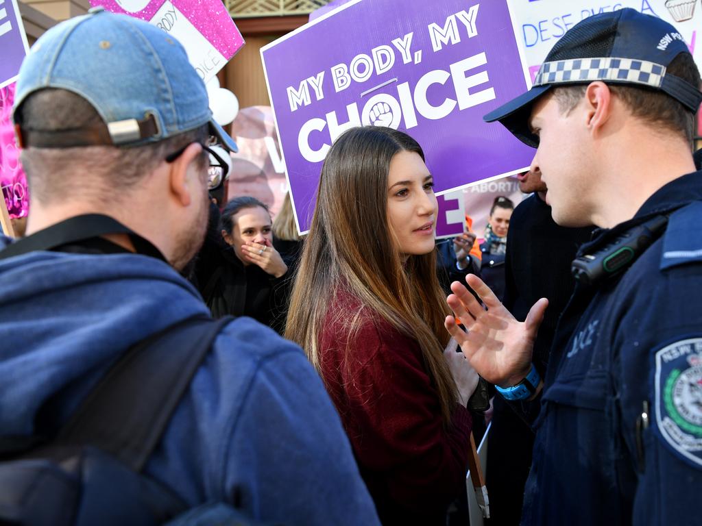 NSW Police speak to a woman during a rally outside the New South Wales Parliament house in Sydney, Tuesday, August 6, 2019. (AAP Image/Joel Carrett)