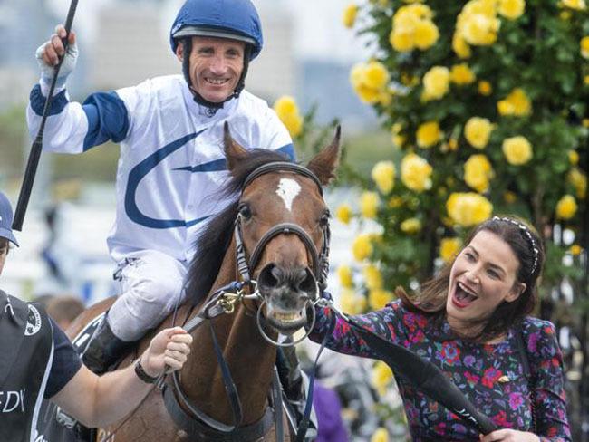 A smiling Damien Oliver is greeted by Nina O'Brien, wife of trainer Danny O'Brien, after Miami Bound's win in the VRC Oaks. Picture: Jay Town