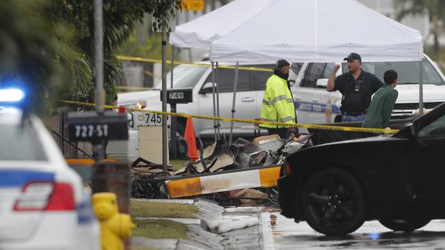 Investigators stand around the wreckage of the  helicopter after the crash.  Picture: AP