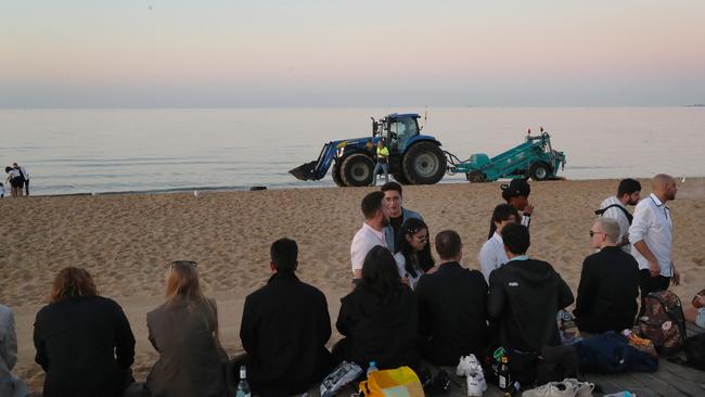 Revellers watch the sunrise on January 1, 2023 at St Kilda Beach. Picture: David Crosling