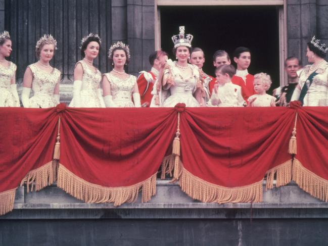 The newly crowned Queen Elizabeth II waves to the crowd from the balcony at Buckingham Palace. Her children Prince Charles and Princess Anne stand with her. Picture: Hulton Archive/Getty Images)