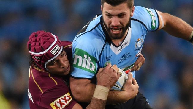 James Tedesco of the Blues is tackled by Johnathan Thurston.