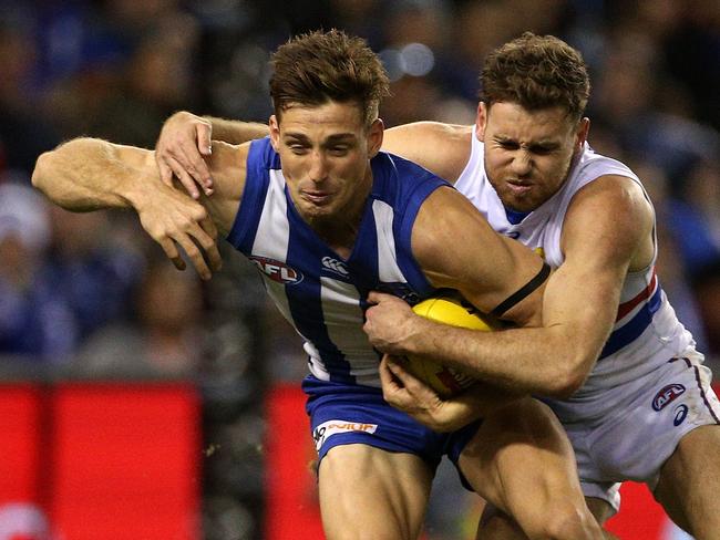 Shaun Atley of the Kangaroos is tackled by Hayden Crozier of the Bulldogs during the Round 21 AFL match between the North Melbourne Kangaroos and the Western Bulldogs at Etihad Stadium in Melbourne, Sunday, August 12, 2018. (AAP Image/Hamish Blair) NO ARCHIVING, EDITORIAL USE ONLY