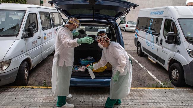 A primary health care nurse disinfects her workmate after attending a patient during a domiciliary visit on June 1 in Sant Andreu de la Barca. Picture: David Ramos/Getty Images