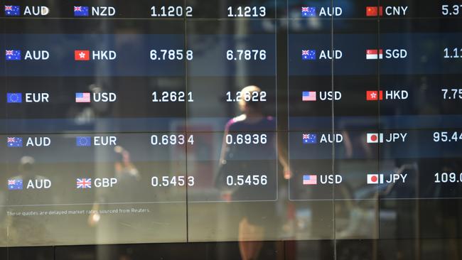 A pedestrian passes by currency prices on display at a bank on a street in Sydney on October 7, 2014. The Australian dollar hit a four-year-low of 86.43 US cents in New York last week as Australia's economy struggles to transition away from resources-led growth following an unprecedented boom in mining investment that is expected to fall-off sharply over the next year. AFP PHOTO/Peter PARKS