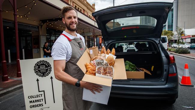 Sam Bentley from artisan sourdough bakery and patisserie, Dough, in the Adelaide Central Market, loading a shopper['s car. Picture: Matt Turner