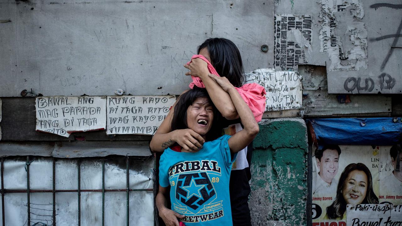 Analyn Roxas and her sister, cry as her partner, Valien Mendoza, a suspected drug dealer, was gunned down by unidentified assailants in Manila in 2017. Picture: Noel Celis/AFP