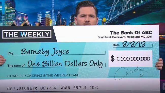 The Weekly host Charlie Pickering offers Barnaby Joyce a cheque for $1 billion. Picture: ABC