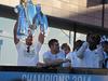 Manchester City's Belgian defender Vincent Kompany (L) holds up the Premiership Trophy as he and team-mates take part in a victory parade on an open-topped bus through the streets of Manchester, northwest England, on May 12, 2014, after becoming the English Premier League champions. Manchester City beat West Ham 2-0 on Sunday to finish two points clear of second-placed Liverpool. AFP PHOTO / LINDSEY PARNABY