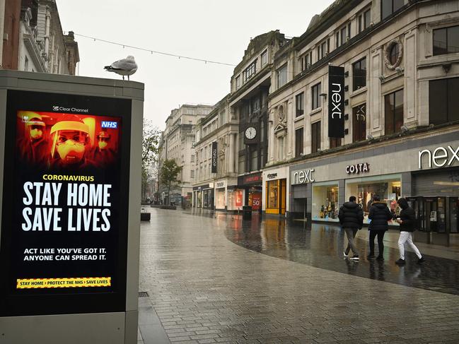 Pedestrians walk past COVID-19 information boards in Liverpool, on January 13, 2021, as non-essential retailers keep their shops closed, due to England's third lockdown. Picture: AFP