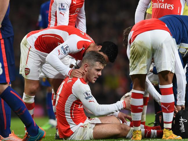 Arsenal’s Jack Wilshere sits injured during the English Premier League soccer match between Arsenal and Manchester United at the Emirates Stadium, London, Saturday, Nov. 22, 2014. (AP Photo/Tim Ireland)