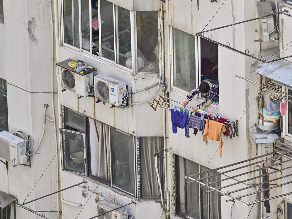 A woman hangs clothes outside her apartment during the second stage of the Covid-19 pandemic lockdown in the Jing'an district of Shanghai Picture: AFP