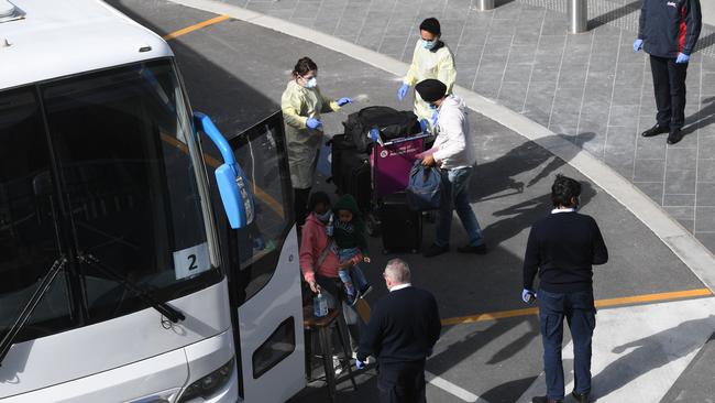 Arrivals from a repatriated flight from India touch down at Adelaide International Airport and are directed to a bus to a city hotel. Picture: Tricia Watkinson