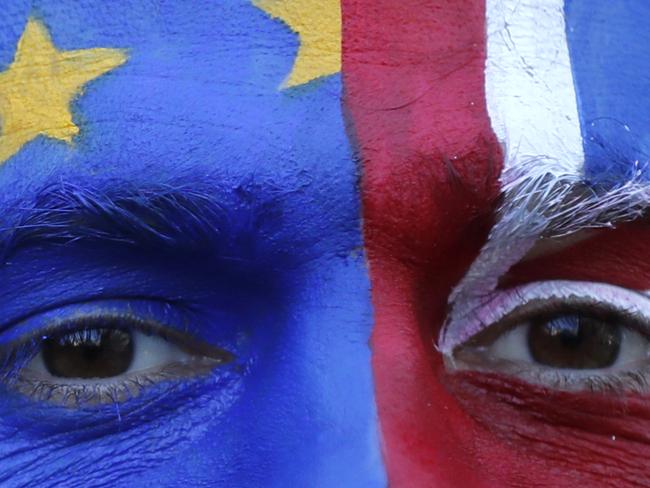 An activist poses with his face painted in the EU and Union Flag colors during an anti-Brexit campaign stunt outside EU headquarters during an EU summit in Brussels, Thursday, March 21, 2019. British Prime Minister Theresa May is trying to persuade European Union leaders to delay Brexit by up to three months, just eight days before Britain is scheduled to leave the bloc. (AP Photo/Frank Augstein)