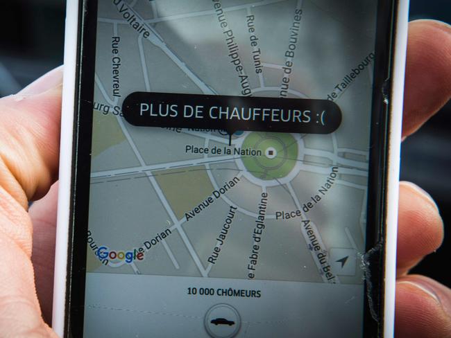 A picture taken on January 9, 2016 in Paris shows a smartphone displaying the app for ride service Uber with a box reading "No more drivers", as Uber suspends the app from 11am to 3pm in support of protesting non-licensed private hire cab drivers. Members of services know in France as "voitures de tourisme avec chauffeur" (VTC - Tousirm vehicle with driver) have been protesting against assurances the French Prime minister has given to taxis. / AFP / Geoffroy Van der Hasselt