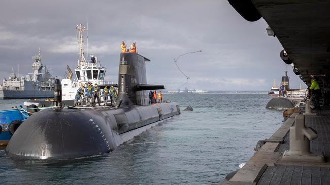 A casing party member casts a heaving line to members of HMAS Stirling Port Sevices as HMAS Farncomb prepares to berth alongside it's home port of Fleet Base West, Western Australia.