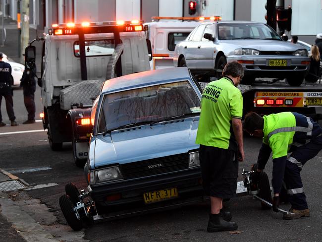 Police oversee as a car is removed from outside a crime scene in Surry Hills, Sydney. Picture: AAP Image/Joel Carrett.