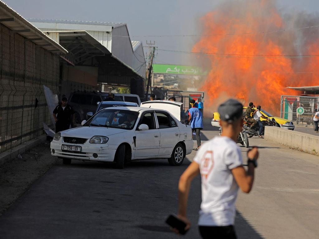 Palestinians and militants from the Ezzedine al-Qassam Brigades run towards the Erez crossing between Israel and the northern Gaza Strip. Picture: AFP