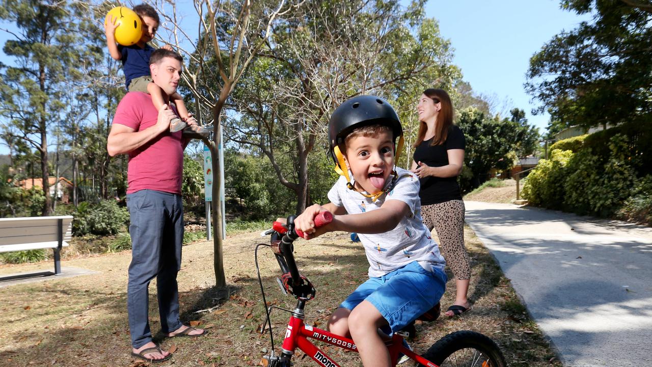 Natasha and Cameron D’Arcy in the park with their kids Wilbur (on the bike) and Victor. Picture: AAP