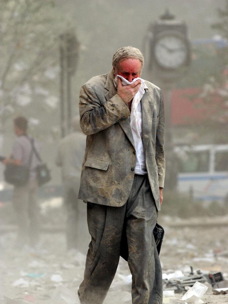 A survivor walks through the debris following the collapse of one of the twin towers of the World Trade Centre. Picture: AFP