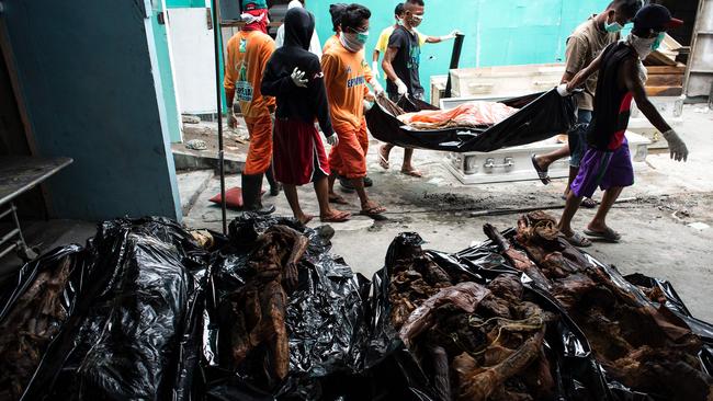 Workers carrying cadavers in various stages of decomposition at the morgue of Henry's Funeral Homes in Manila, October 2016. Picture: AFP / Noel Celis.
