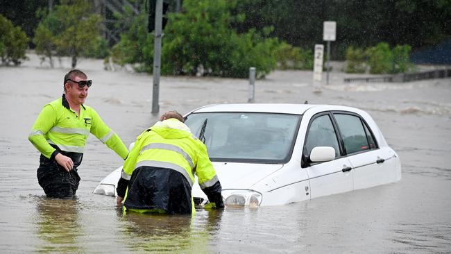 Tow truck drivers rescue a car from floodwaters in Widdop st, Nundah. Picture: NCA NewsWIRE / John Gass