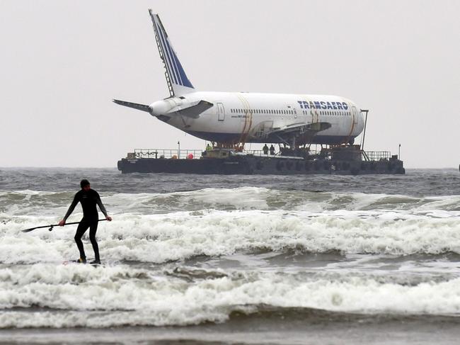 ONLINE ONLY A paddle boarder is seen as Boeing 767 airplane arrives the Enniscrone estuary after it was tugged from Shannon airport out to sea around the west coast of Ireland, May 7, 2016. It is destined for local funeral director David McGowan's proposed Glamping Village to be used as accommodation in Sligo, Ireland. REUTERS/Clodagh Kilcoyne - RTX2D9B7