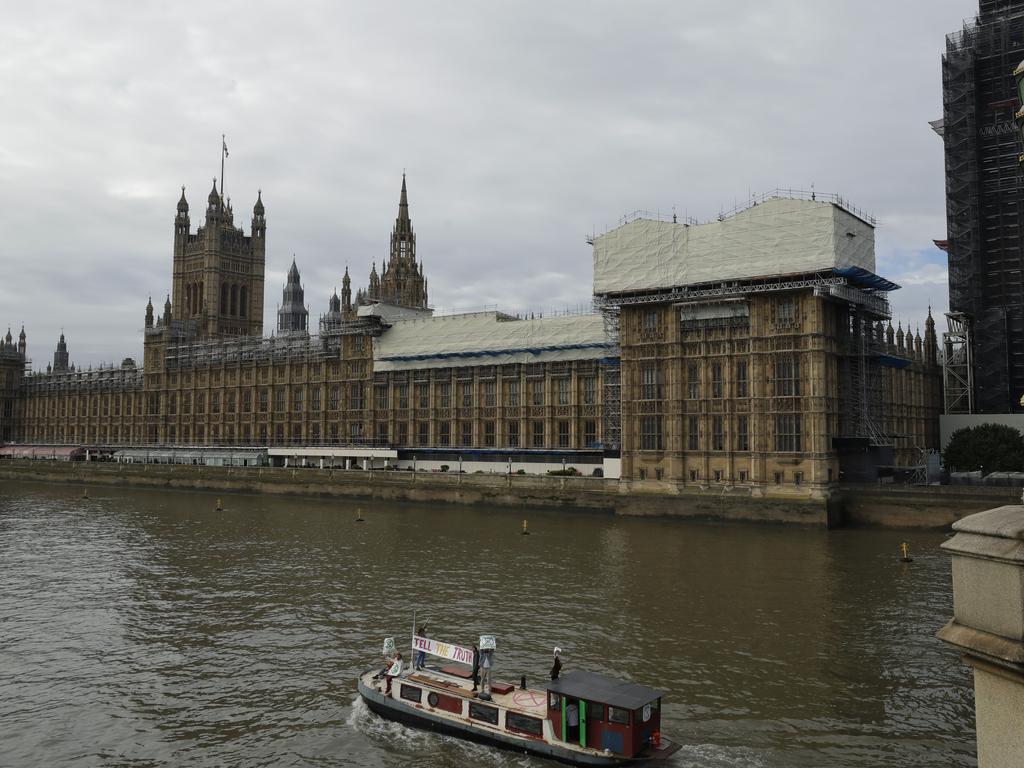The boat with a banner saying "Tell the Truth" passes Britain's Parliament. Picture: AP/Matt Dunham.