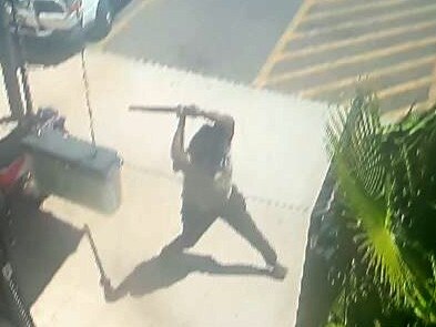 A group of a dozen men and women engage in conflict brandishing weapons - including machetes and baseball bats - outside The Gap View Hotel in Alice Springs just past midday in September 2022.