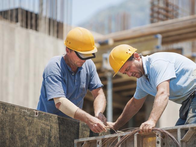 Construction workers working on cement formwork frames