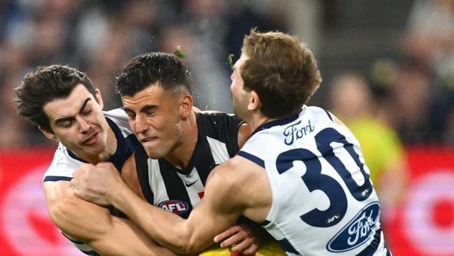 MELBOURNE, AUSTRALIA - MAY 03: Nick Daicos of the Magpies is tackled by Oisin Mullin and Tom Atkins of the Cats during the round eight AFL match between Collingwood Magpies and Geelong Cats at Melbourne Cricket Ground, on May 03, 2025, in Melbourne, Australia. (Photo by Quinn Rooney/Getty Images)