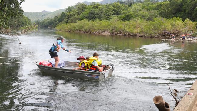 Goldsborough resident Sonya Bielek pulls a small boat across the Mulgrave River to complete the daily school run after flood waters washed the Fisheries Bridge away on December 18. Picture: Peter Carruthers