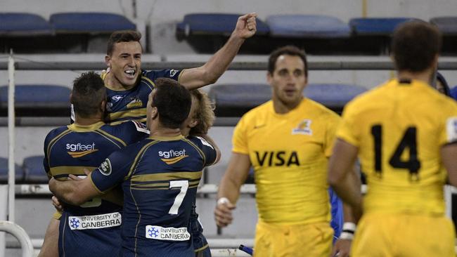 Brumbies fullback Tom Banks celebrates with teammates after scoring the third try.