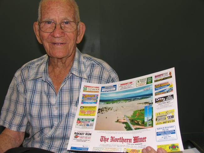 Charters Towers identity Fred Bagnall with The Northern Miner’s 2010 calendar that featured a photograph of the near record-breaking February 2009 Burdekin River flood and the flood marker that was erected at his initiative.