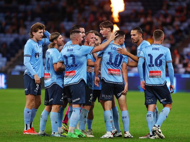 Joe Lolley (10) grabs his hamstring while being congratulated by his Sydney FC teammates after scoring against Macarthur FC. Picture: Jeremy Ng/Getty Images