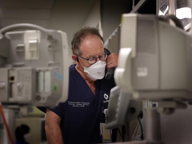 Professor Mark Fitzgerald on the phone dealing with a serious spinal injury. Picture: David Caird