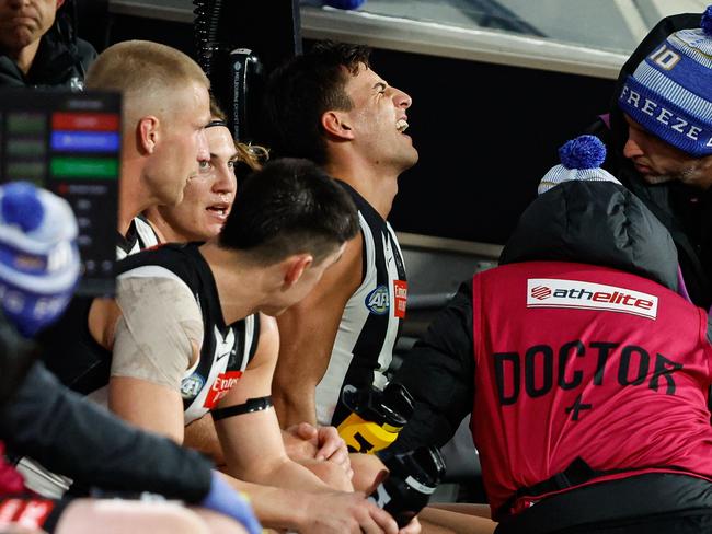 MELBOURNE, AUSTRALIA - JUNE 10: Nick Daicos of the Magpies is assessed by medical staff on the bench during the 2024 AFL Round 13 match between the Collingwood Magpies and the Melbourne Demons at The Melbourne Cricket Ground on June 10, 2024 in Melbourne, Australia. (Photo by Dylan Burns/AFL Photos via Getty Images)