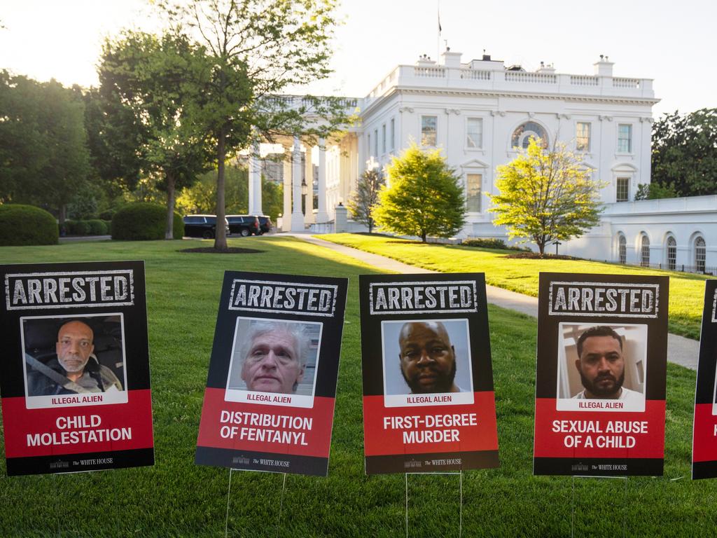 Signs showing photos of what are described as illegal aliens who have been arrested line a driveway at the White House. Picture: AP