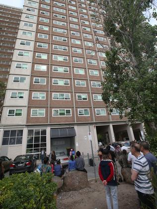 Residents gather outside the building.