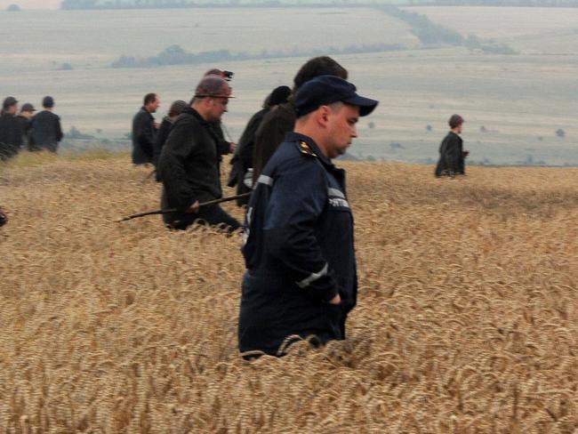 TOPSHOTS A group of Ukrainian miners assist rescue workers in the search for bodies of victims in a wheat field at the site of the crash of a Malaysian airliner carrying 298 people from Amsterdam to Kuala Lumpur in Grabove, in rebel-held east Ukraine, on July 18, 2014. Pro-Russian separatists in the region and officials in Kiev blamed each other for the crash, after the plane was apparently hit by a surface-to-air missile. Members of the UN Security Council demanded a full, independent investigation into the apparent shooting down of a Malaysia Airlines jet over Ukraine. AFP PHOTO / DOMINIQUE FAGET
