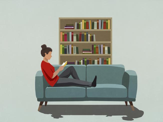 Woman reading book on sofa. Picture: Getty Images