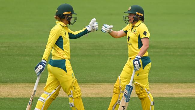 BRISBANE, AUSTRALIA - OCTOBER 08: Phoebe Litchfield and  Alyssa Healy of Australia bump gloves during game one of the One Day International series between Australia and the West Indies at Allan Border Field on October 08, 2023 in Brisbane, Australia. (Photo by Albert Perez/Getty Images)