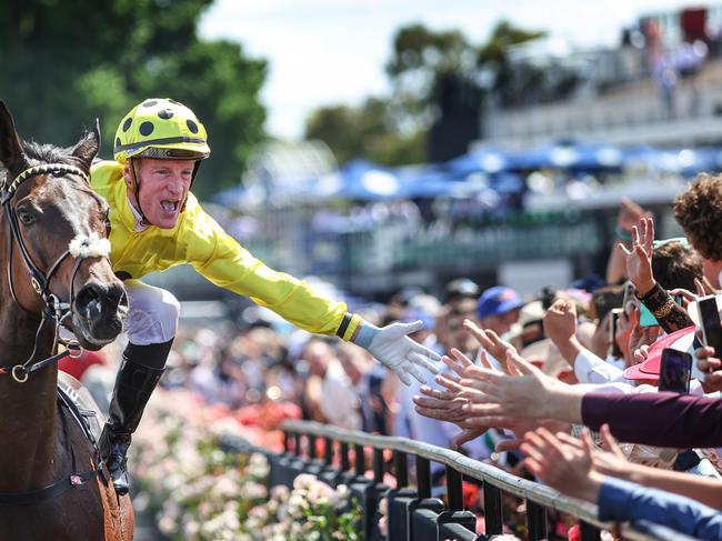 2023 Melbourne Cup Flemington. Running off the Melbourne Cup. Winning jockey Mark Zahra high fives the crowd on race horse Without A Fight on return to scale.     Picture: David Caird