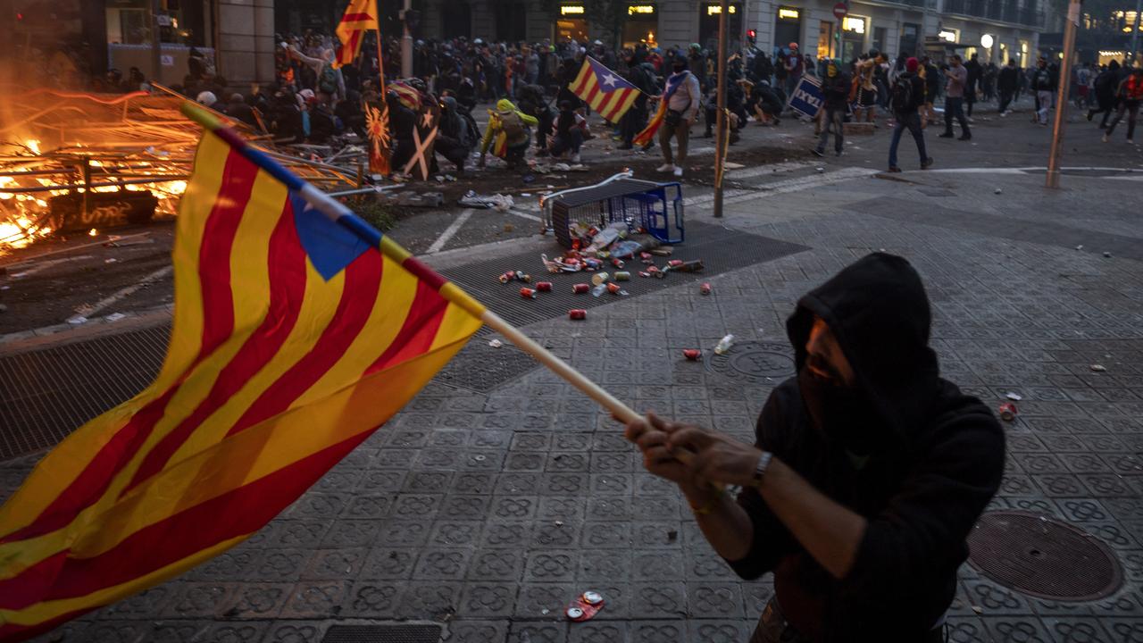 A demonstrator waves a flag as protesters clash with police in Barcelona, Spain. Picture: AP